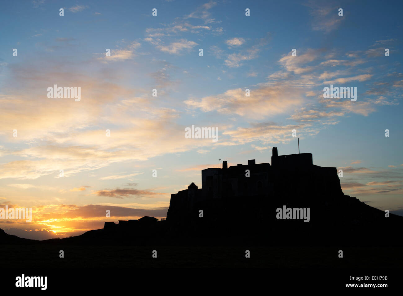 Lindisfarne Castle at sunrise on Holy Island, Northumberland, England. Silhouette Stock Photo