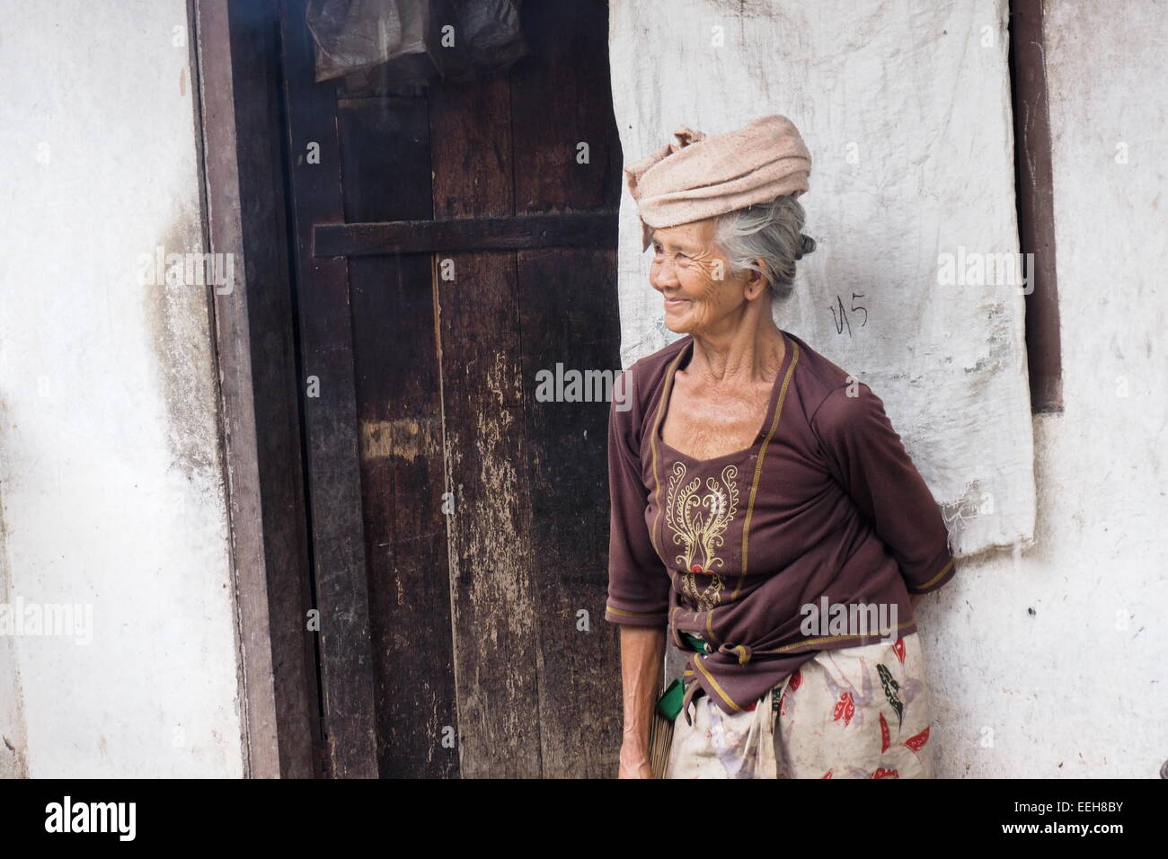 Elderly Balinese lady in traditional dress outside her home. Stock Photo