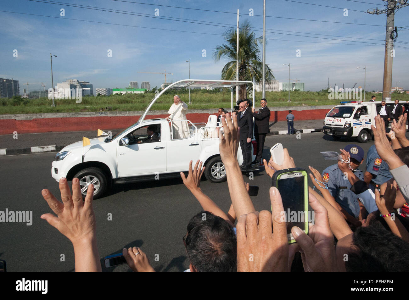 Baclaran, Philippines. 19th Jan, 2015. Pope Francis waves to the people on his motorcade to the Villamor Airbase in Baclaran, Paranaque on Monday, January 19, 2015. Pope Francis is on his way back to the Vatican after a 5-day visit to the Philippines. Credit:  Mark Fredesjed Cristino/Alamy Live News Stock Photo