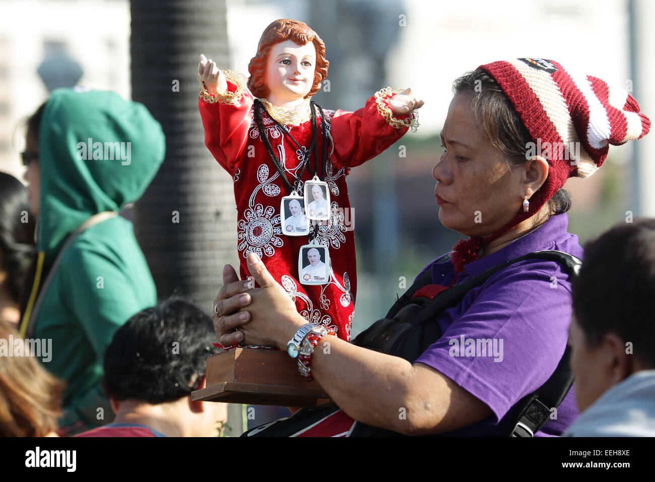 Baclaran, Philippines. 19th Jan, 2015. A Filipino woman holds on to a statue of Santo Nino wearing Pope Francise necklace while waiting for the Pope's motorcade to the Villamor Airbase in Baclaran, Paranaque on Monday, January 19, 2015. Pope Francis is on his way back to the Vatican after a 5-day visit to the Philippines. Credit:  Mark Fredesjed Cristino/Alamy Live News Stock Photo