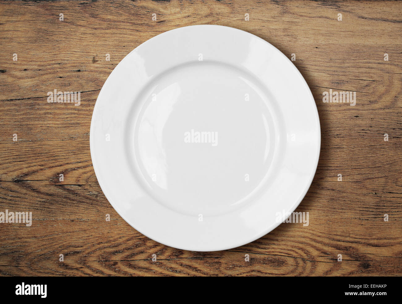 white empty dinner plate on wooden table surface Stock Photo