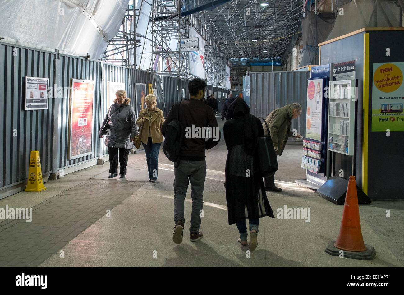 Commuters walk through Manchester Victoria train station while building and renovation work is carried out Stock Photo