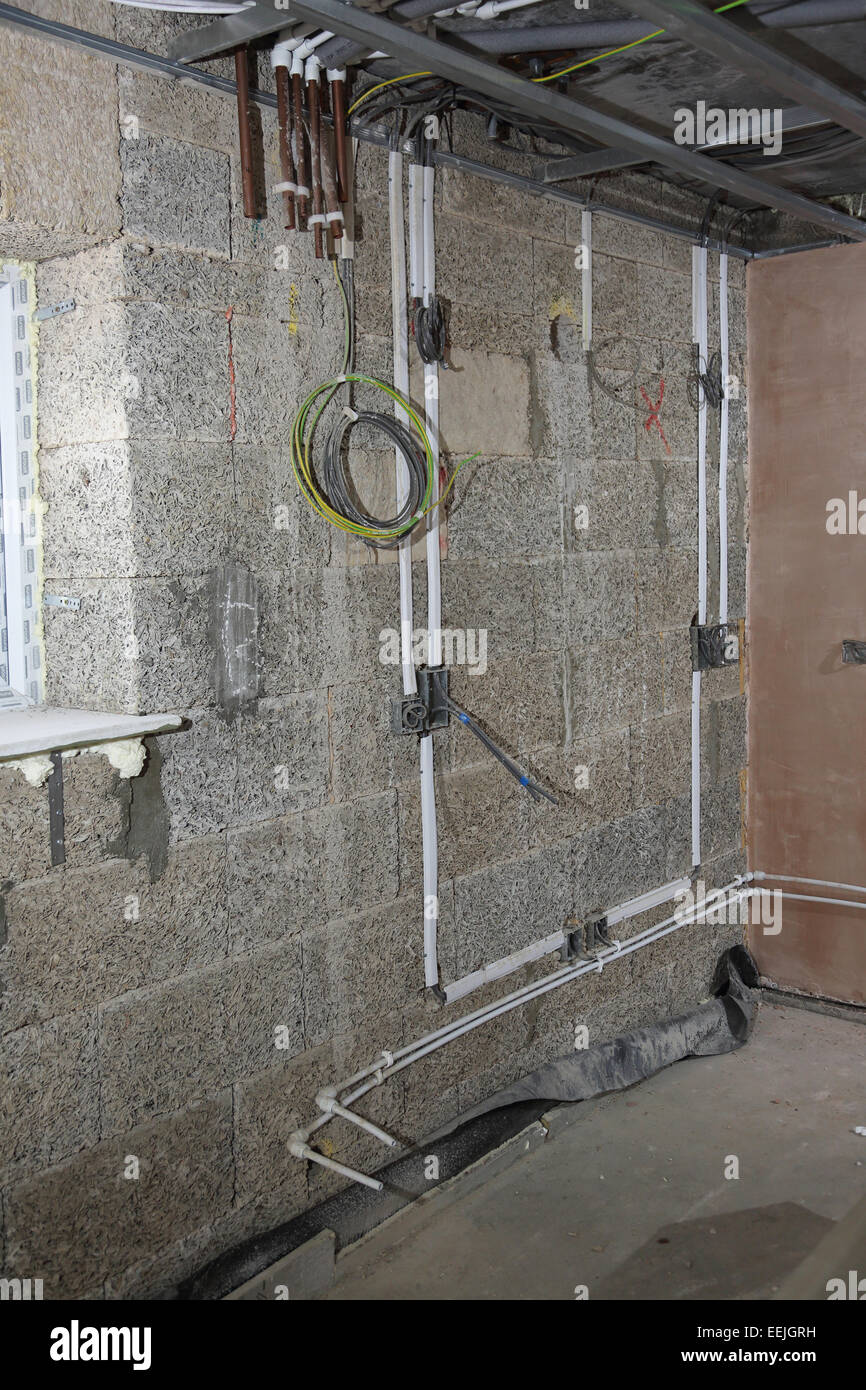 Electrical and plumbing installation on the interior of a new apartment building constructed using wood fibre blocks Stock Photo