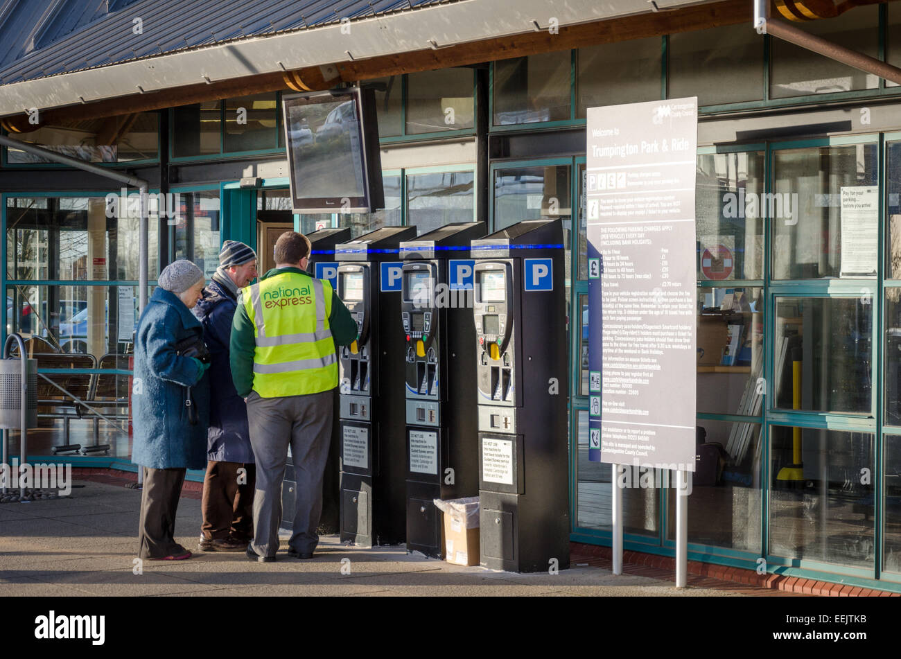National Express employee helps an elderly couple pay for parking at