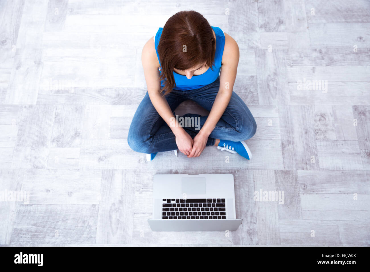 Top view portrait of a young woman sitting on floor with laptop Stock ...
