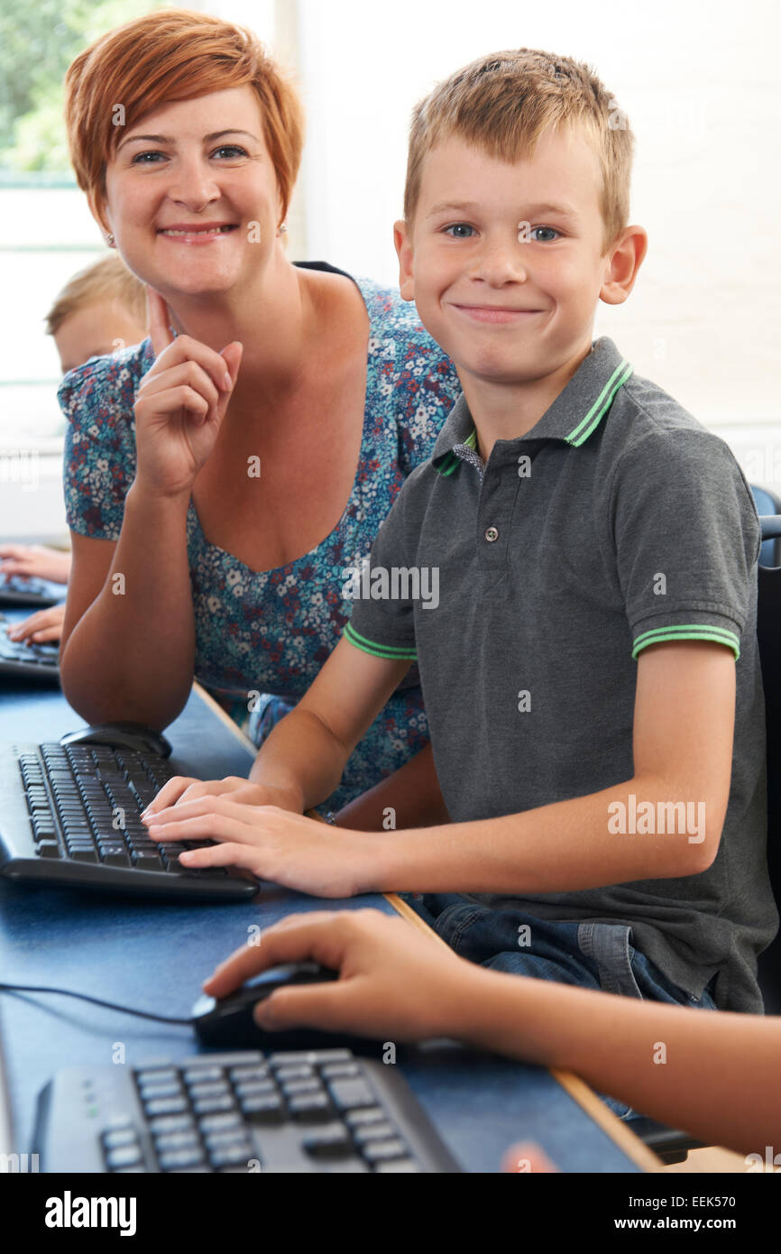 Male Elementary Pupil In Computer Class With Teacher Stock Photo - Alamy