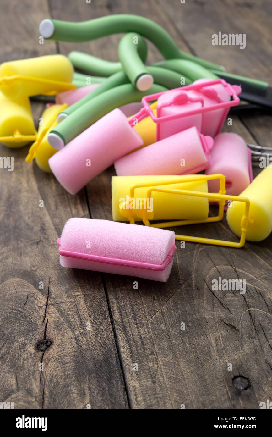 Hair curlers on old wooden table, close up Stock Photo