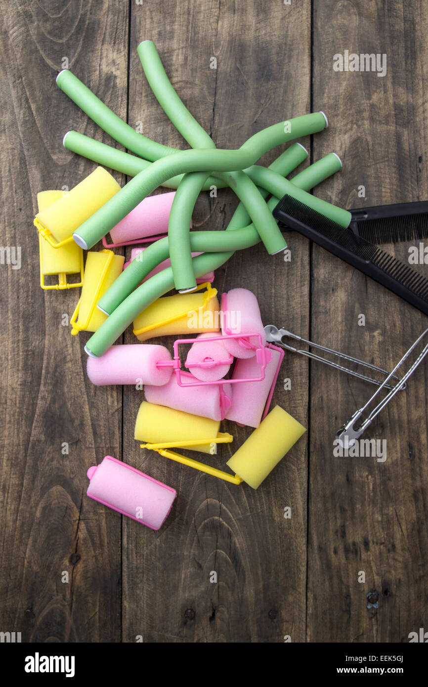Hair curlers on old wooden table, from above Stock Photo