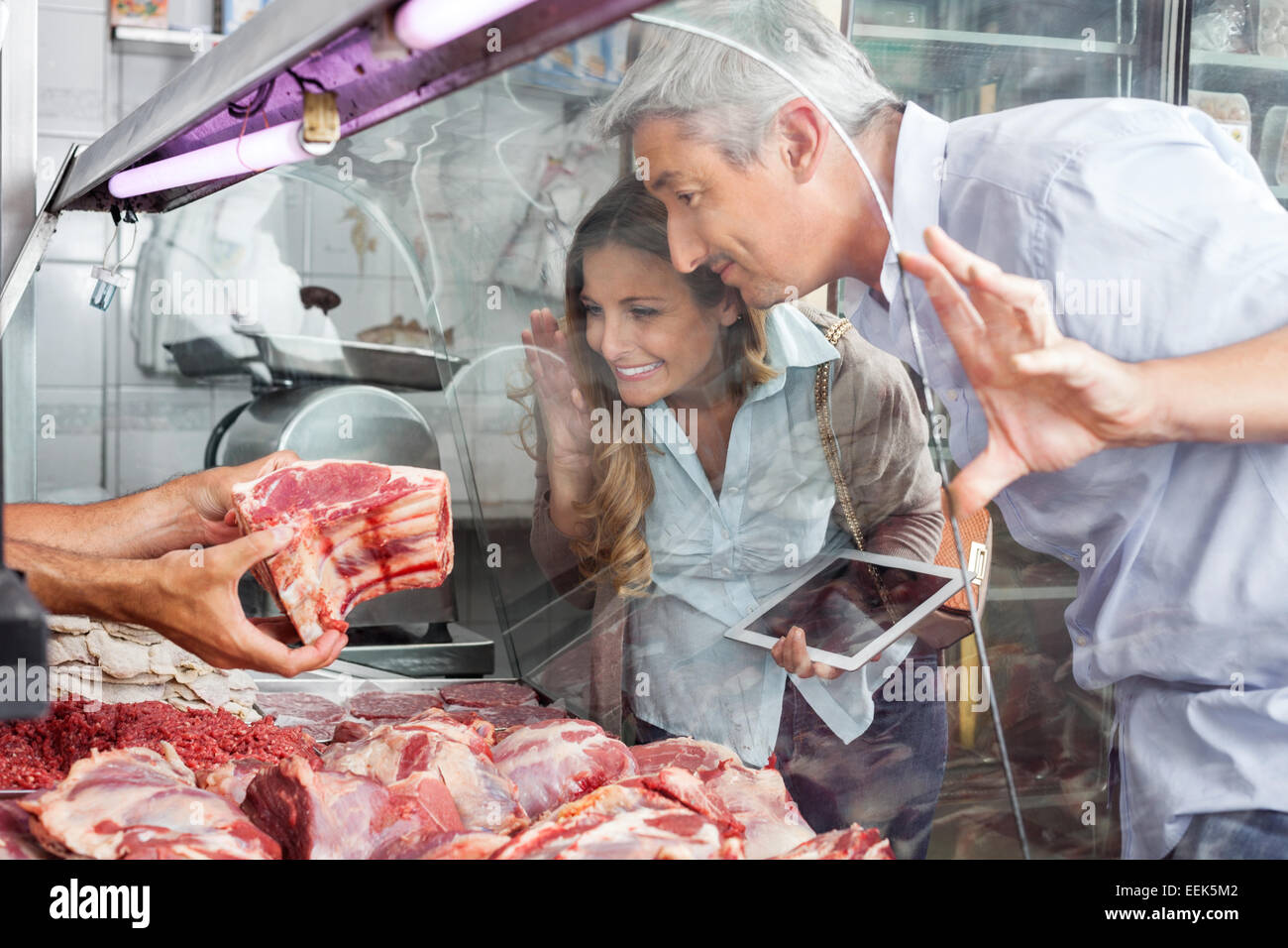 Couple Buying Meat At Butchery Stock Photo