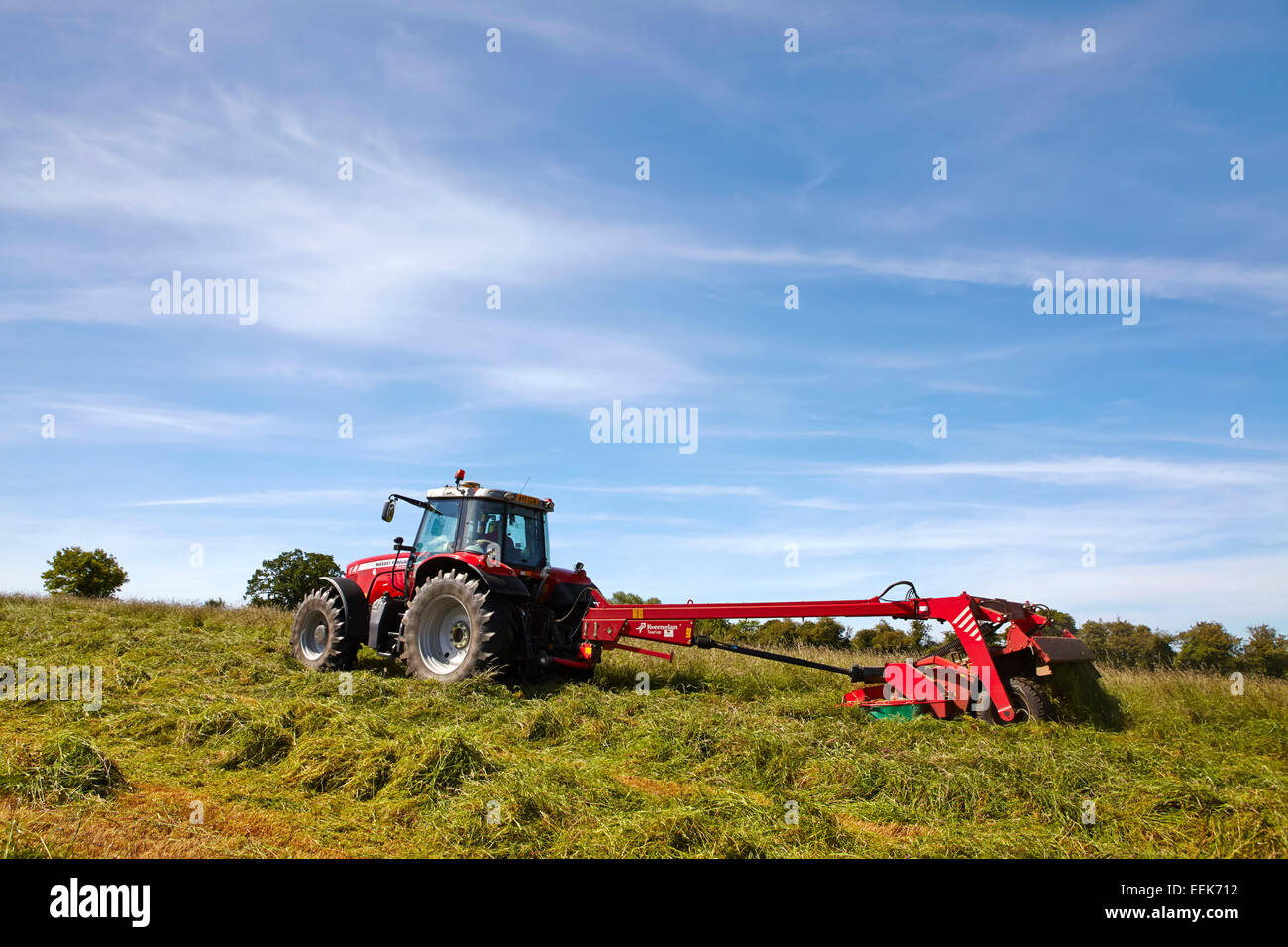 Farmer mowing grass for haylage in summer in Norfolk, UK Stock Photo