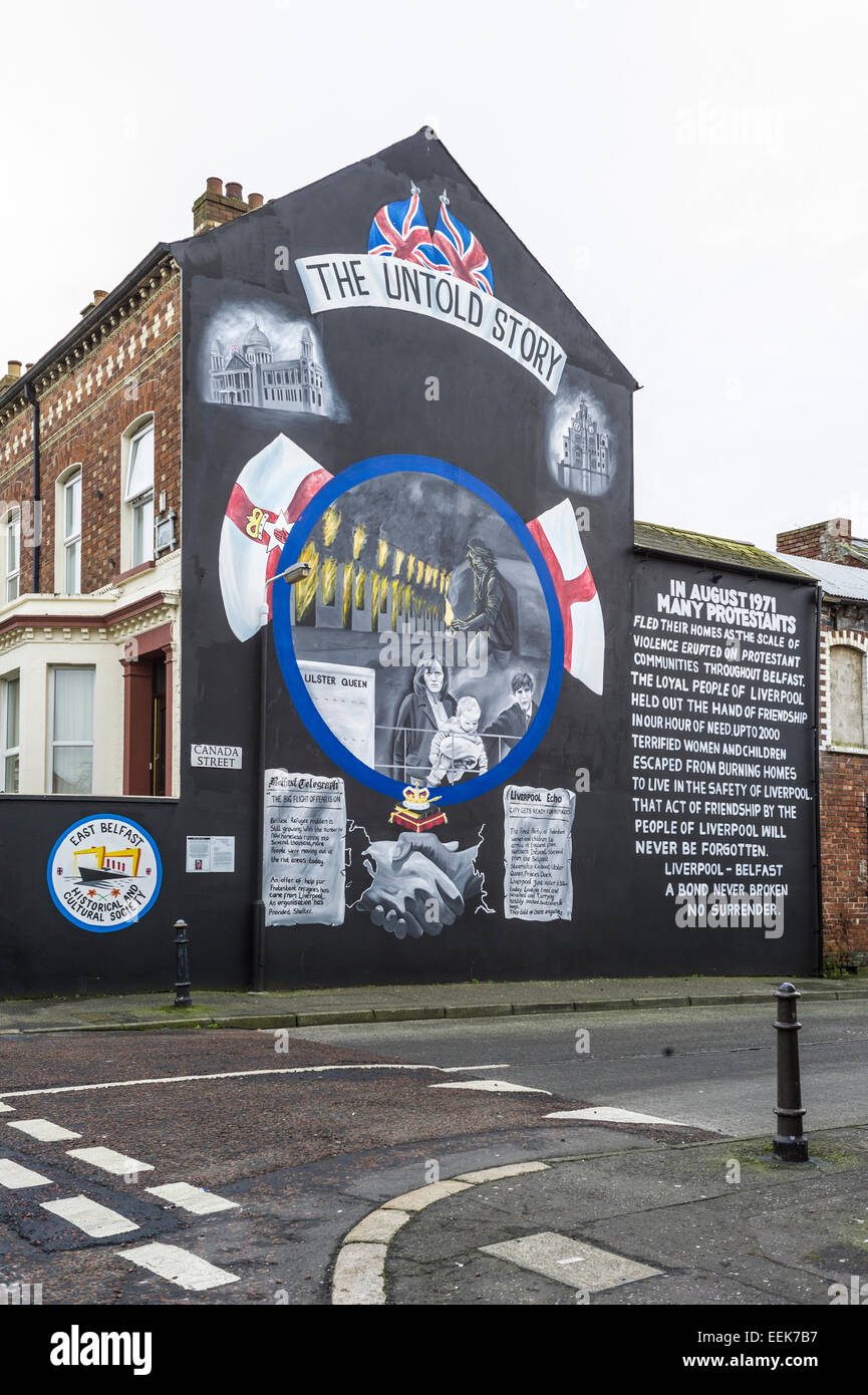 Ulster loyalist wall mural on corner of Canada St Belfast depicting loyalist fleeing to Liverpool. Stock Photo