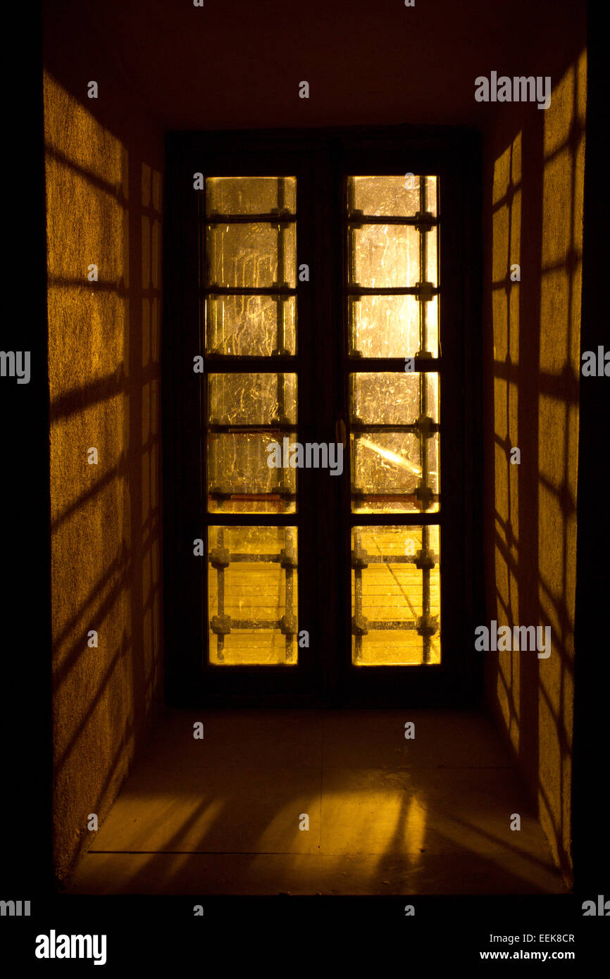 Window with railings of mosque Alatza Imaret in golden light Stock Photo