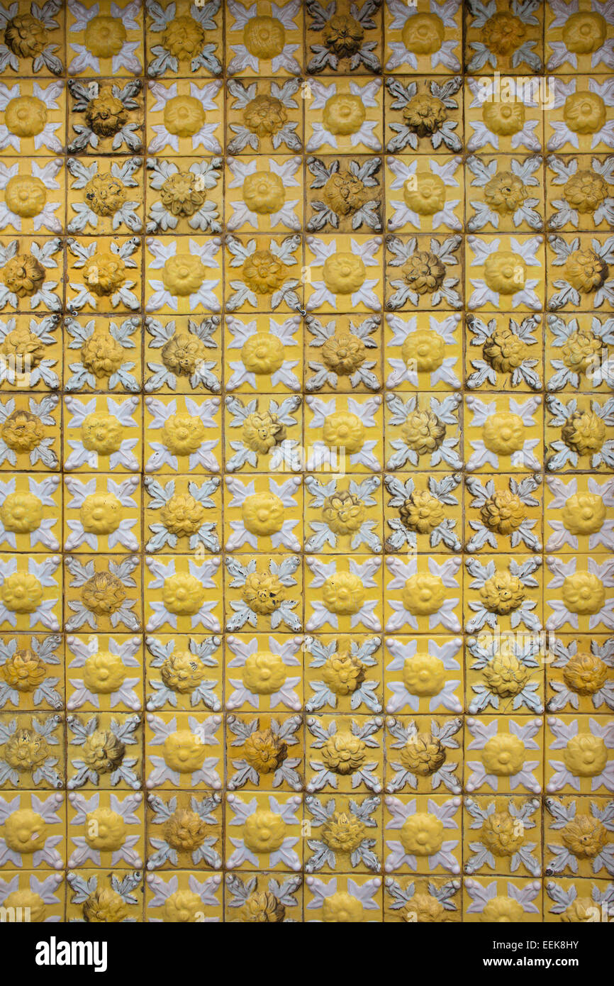 Old, aged, yellow, vintage ceramic tiles background or texture with flower motif. Stock Photo