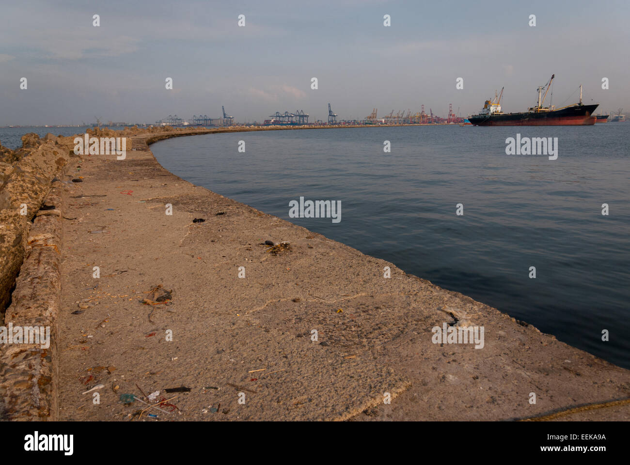 Breakwater structure and a concrete platform on Port of Jakarta's turning basin, with Amanna Gappa general cargo ship can be seen on top right corner. Stock Photo