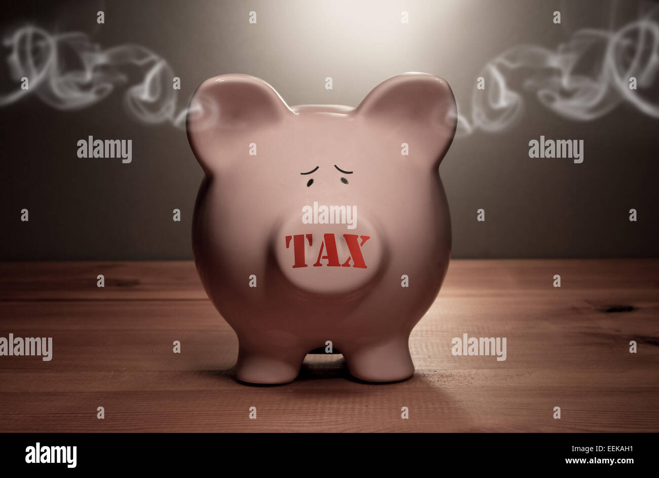 Piggy bank with tax stamp on its forward and smoke coming out of its ears Stock Photo