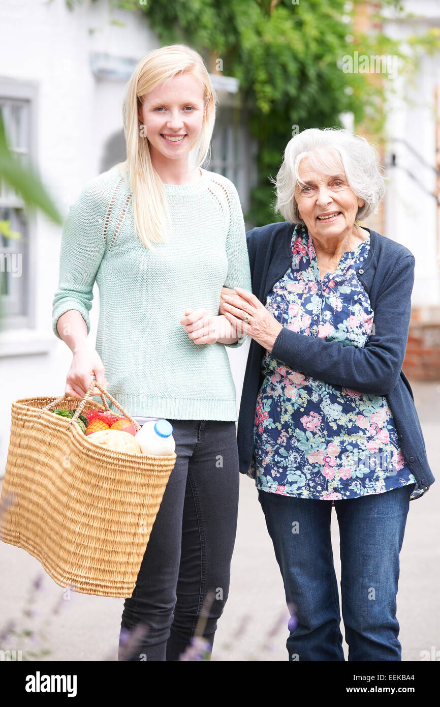 Teenage Girl Helping Senior Woman To Carry Shopping Stock Photo Alamy