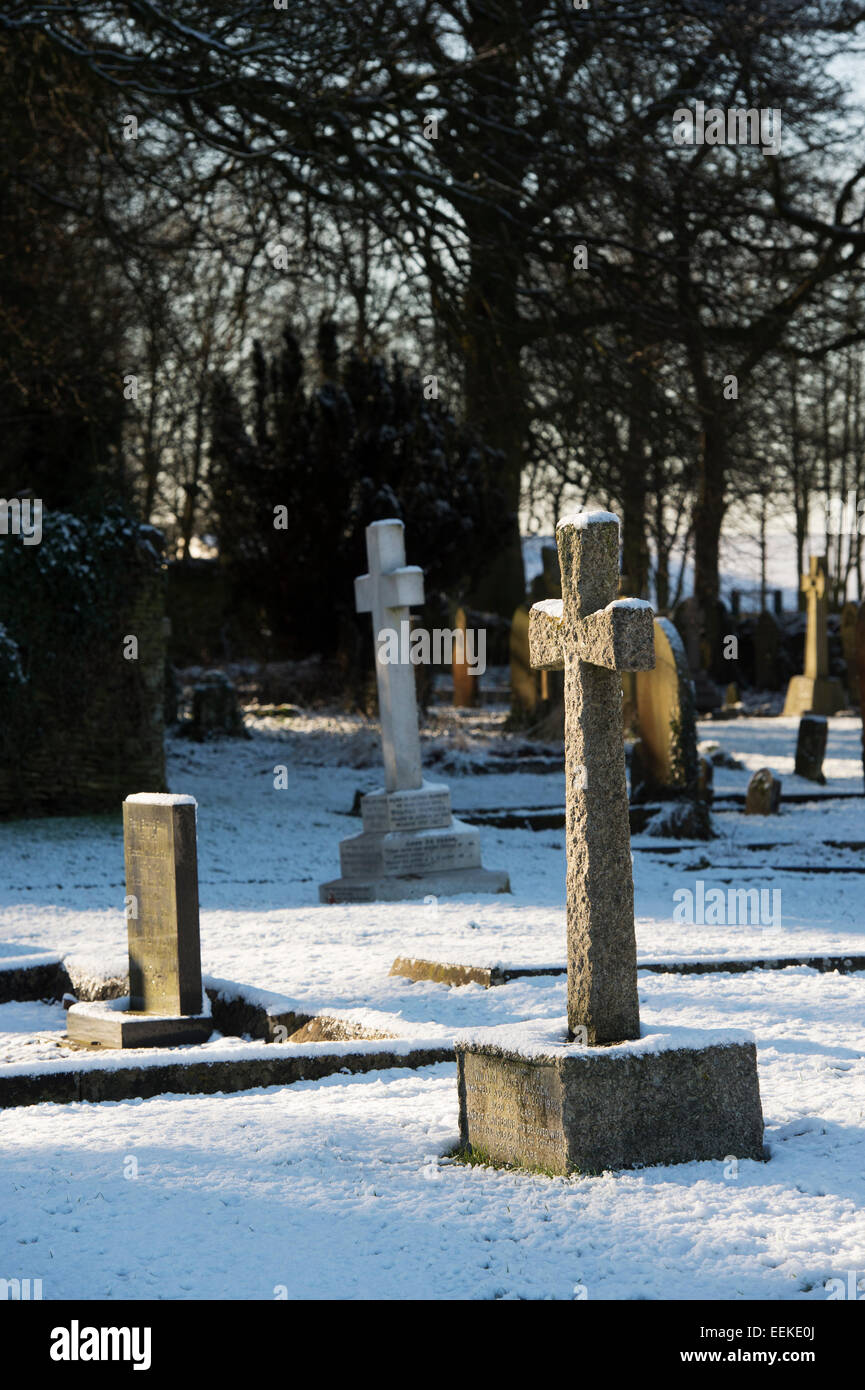 Headstone Cross in the snow in a cemetery. Cotswolds,  England Stock Photo
