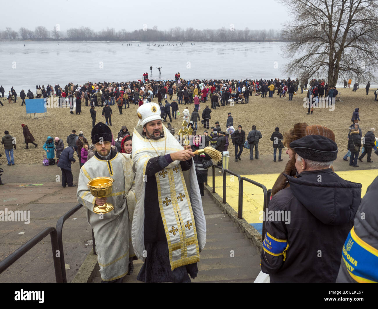Priests sprinkle holy water on the faithful. 19th Jan, 2015. -- 19 January, 2015, Kiev, Ukraine, great Christian holiday Epiphany. One of the main traditions of celebration is swimming in Jordan (the so-called consecrated priest hole). The current winter was unusually mild in Ukraine and swimming just held on the beach. Ukrainian Church of the Moscow Patriarchate traditionally celebrated in Obolon. © Igor Golovniov/ZUMA Wire/Alamy Live News Stock Photo