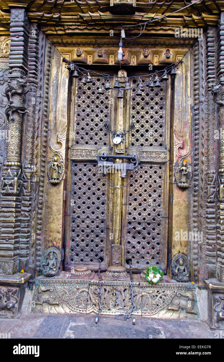 closed ornate decorative temple brass door with locks, Nepal Stock