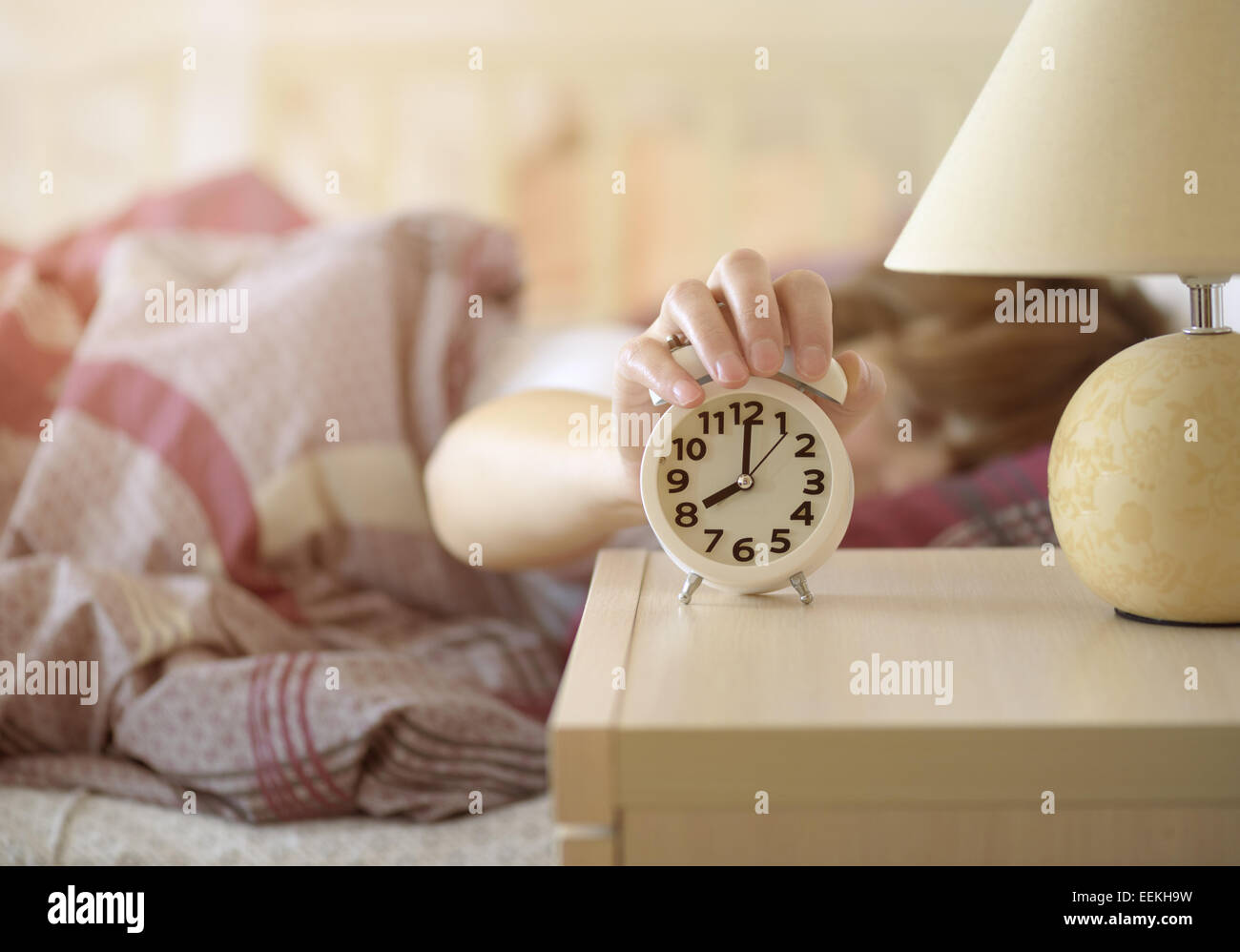 girl turns off the alarm clock waking up in the morning from a call