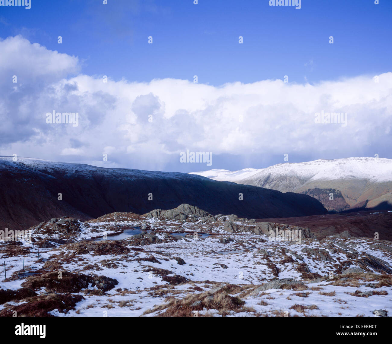 Storm & shower clouds passing over snow capped summit of Helvellyn from