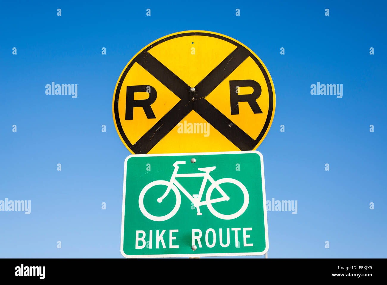 Railroad crossing warning sign, and bike route sign. Stock Photo