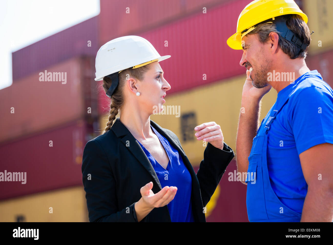 Freight shipping at container terminal of port, worker and manager discussing shipments Stock Photo