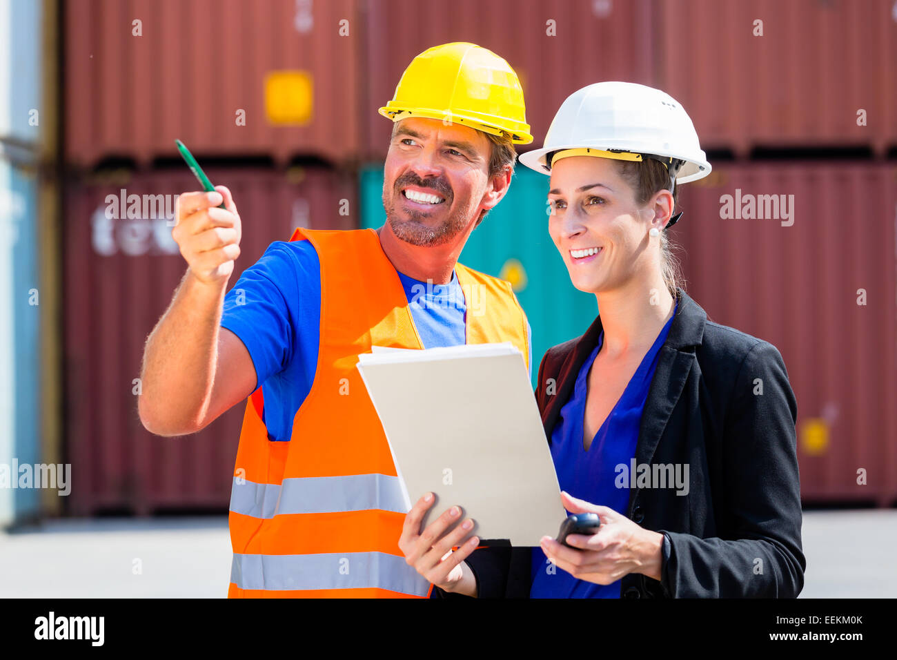Employees in logistics company shipping containers with clipboard Stock Photo