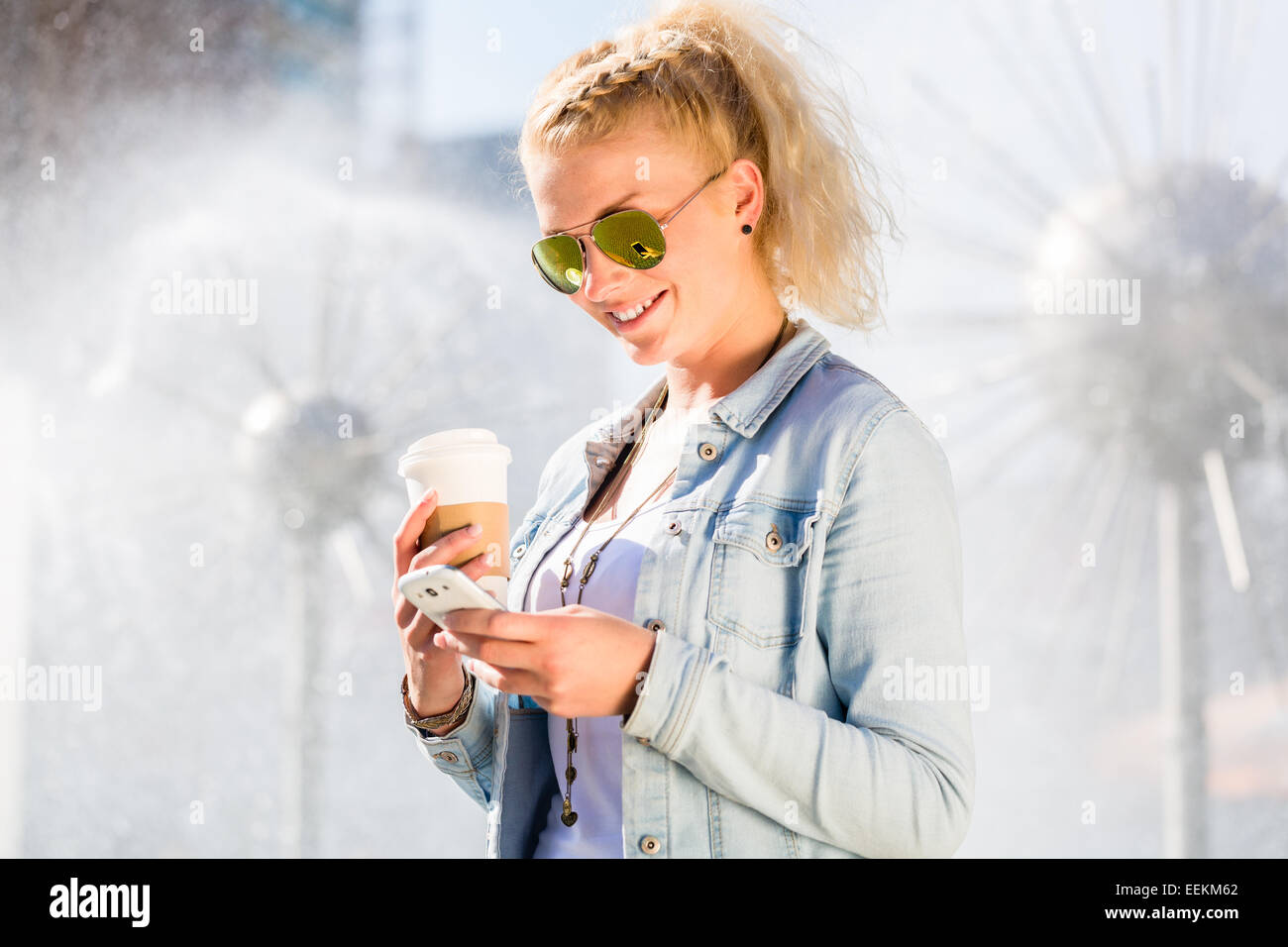 Woman at Fountain with Phone and coffee to takeaway Stock Photo Alamy
