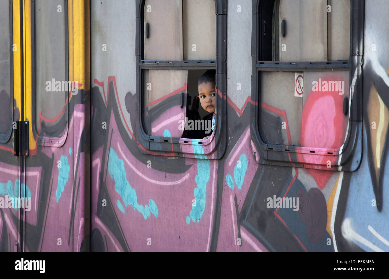 Child looking from the window of a Cape Town train in South Africa Stock Photo