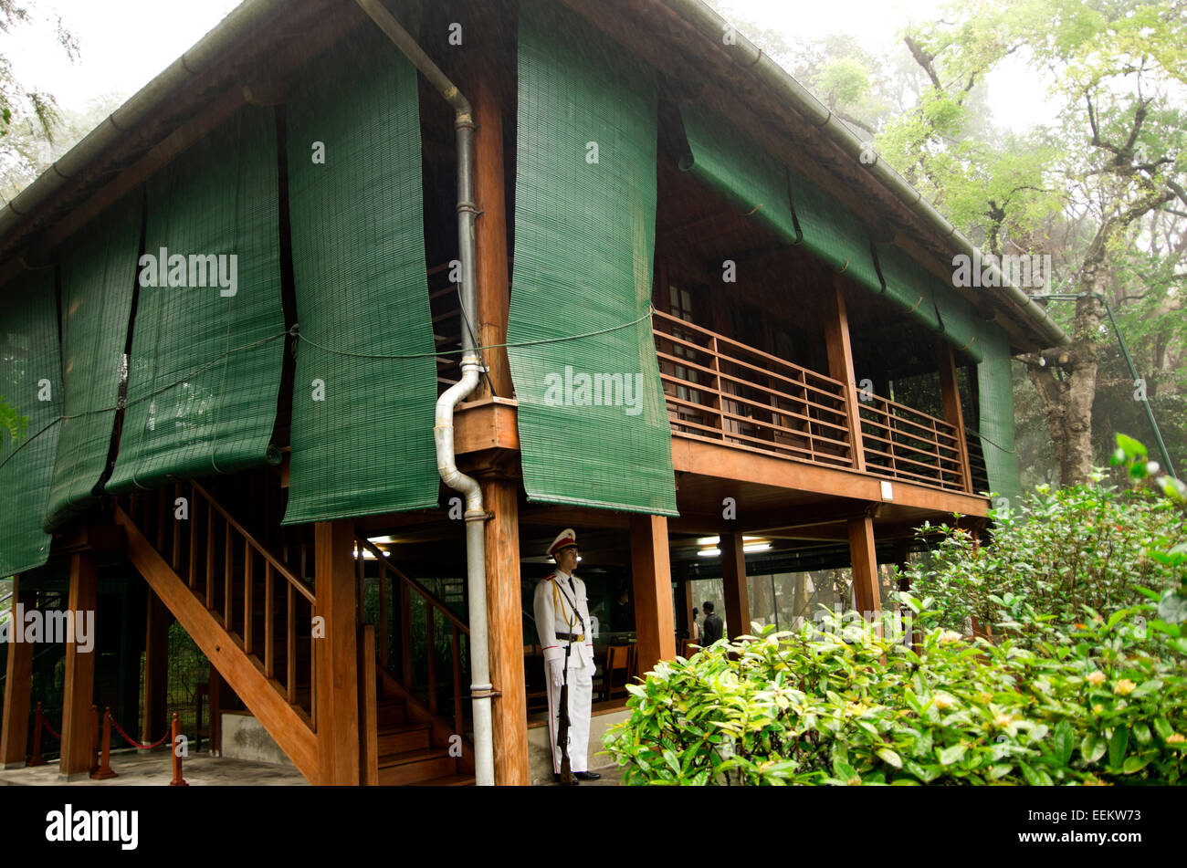 Ho Chi Minh's stilt house, his official residence in complex.  Soilder in white uniform stands guard at bottom of stairs. Stock Photo