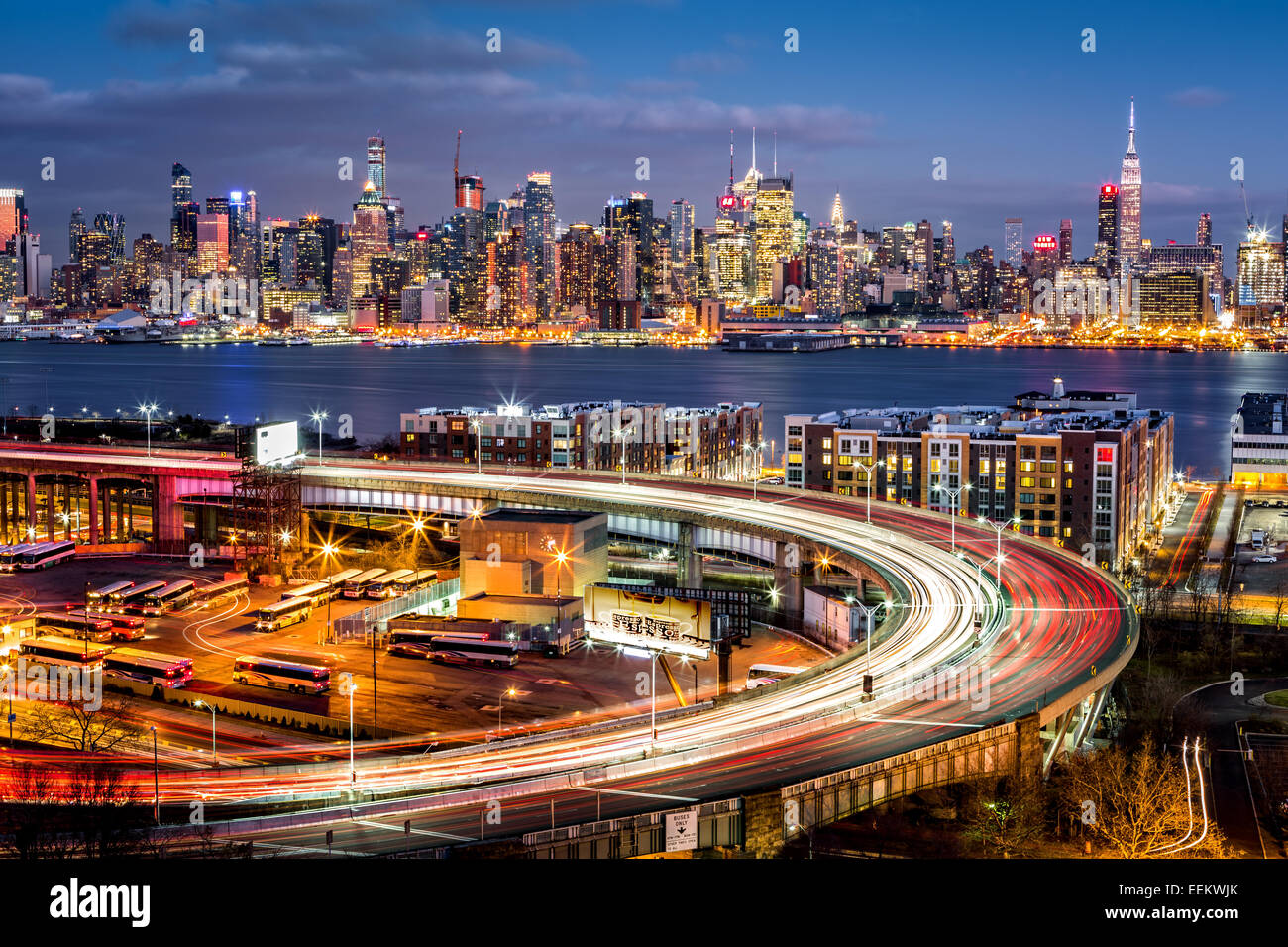 Traffic and light trails on The Helix, a highway loop at the entrance in Lincoln Tunnel. The New York skyline shines in the back Stock Photo