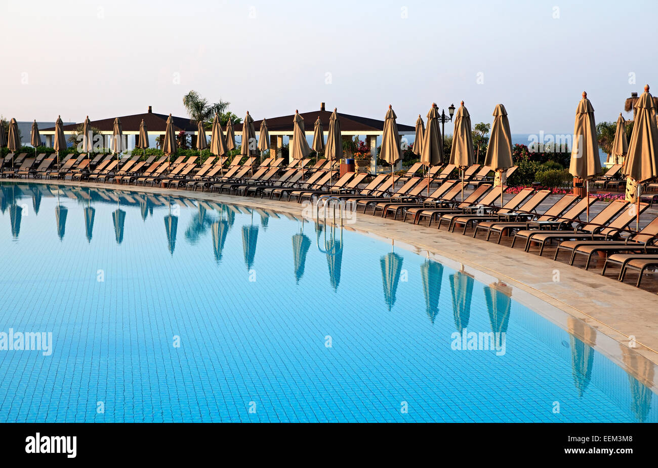 Chaise longue and umbrellas near the pool Stock Photo - Alamy