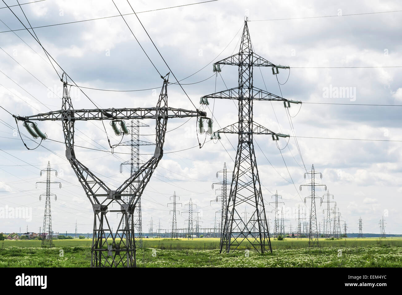 Two types of electrical power lines towers withing a large network for energy distribution Stock Photo