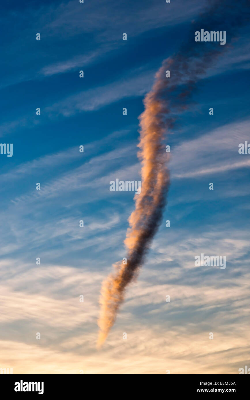 Almost perpendicular cloud, contrail resolving, in the evening light, North Rhine-Westphalia, Germany Stock Photo