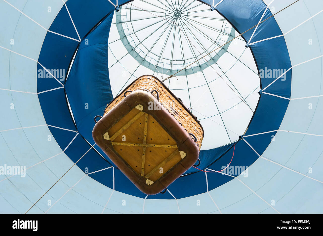 Suspended hot air balloon with passenger carrying basket viewed from below Stock Photo