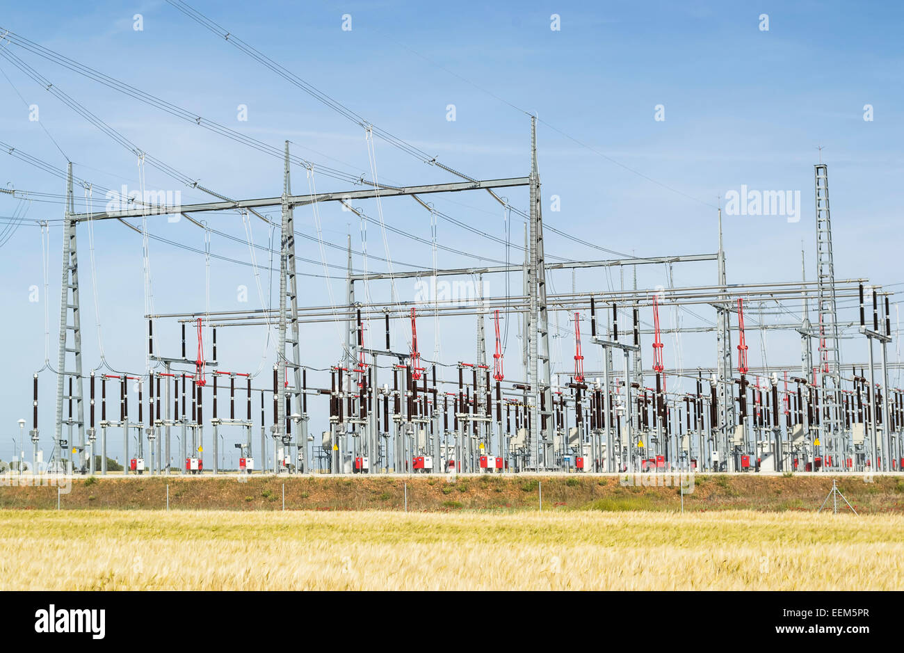 Electrical equipment of a power station elevated above a wheat field Stock Photo