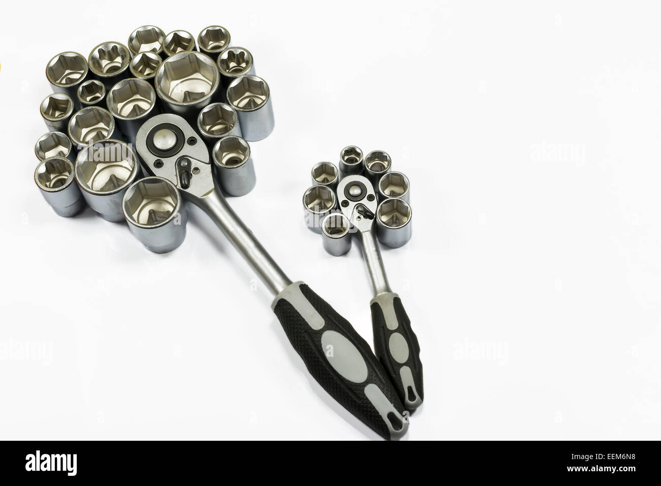 Two socket wrenches with hexagonal bits arranged around them as to resemble the petals of a flower, isolated on white Stock Photo