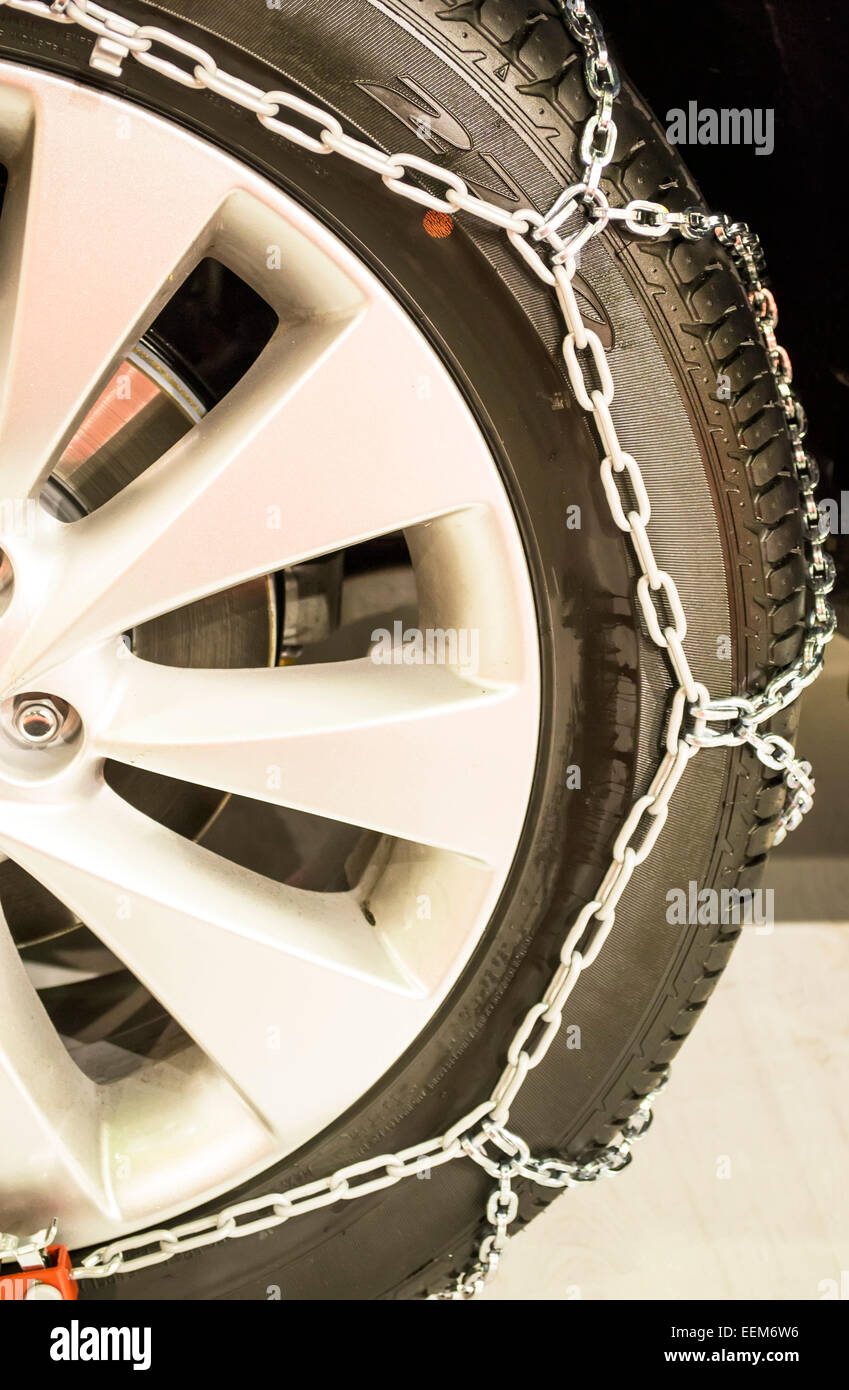 Winter tire  equipped with metal chain around it for better road grip in winter time conditions Stock Photo