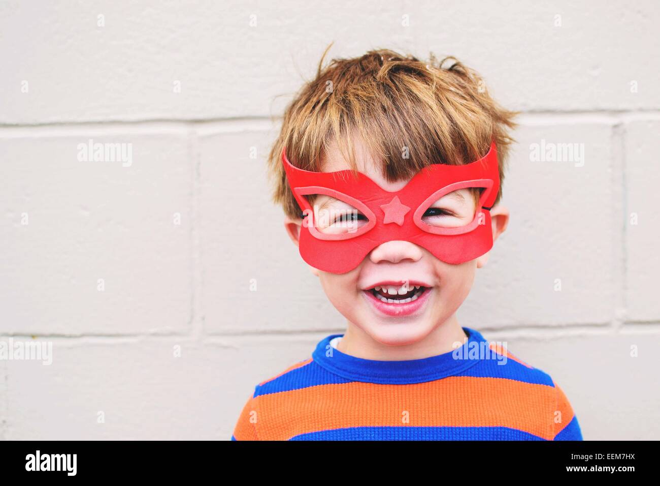Portrait of a smiling boy wearing superhero mask Stock Photo