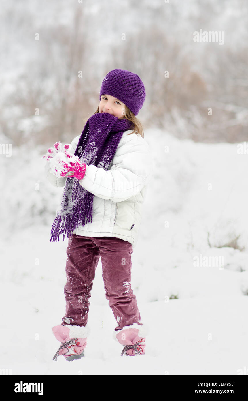 Girl (6-7) playing in snow Stock Photo