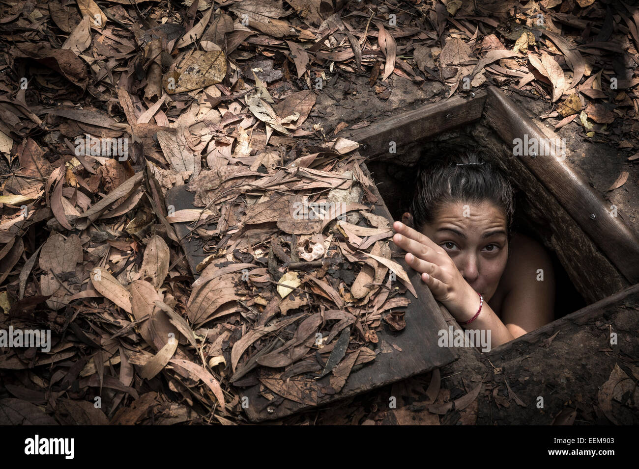 Complex Cu Chi tunnels. A tourist attempts to pass through a small outputs used by the Vietnamese soldiers to enter the tunnels. Stock Photo