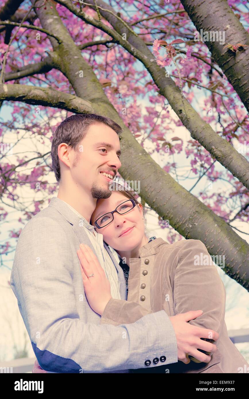 Couple standing under a blossoming tree Stock Photo