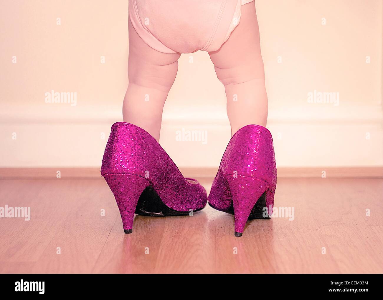 Toddler wearing mother's shoes Stock Photo
