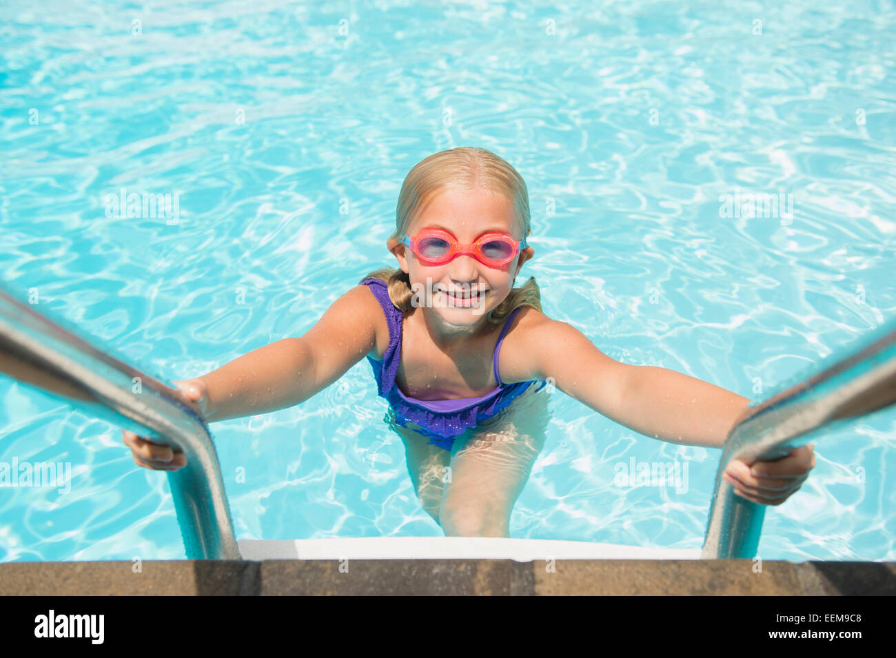 Caucasian girl climbing out of swimming pool Stock Photo Alamy
