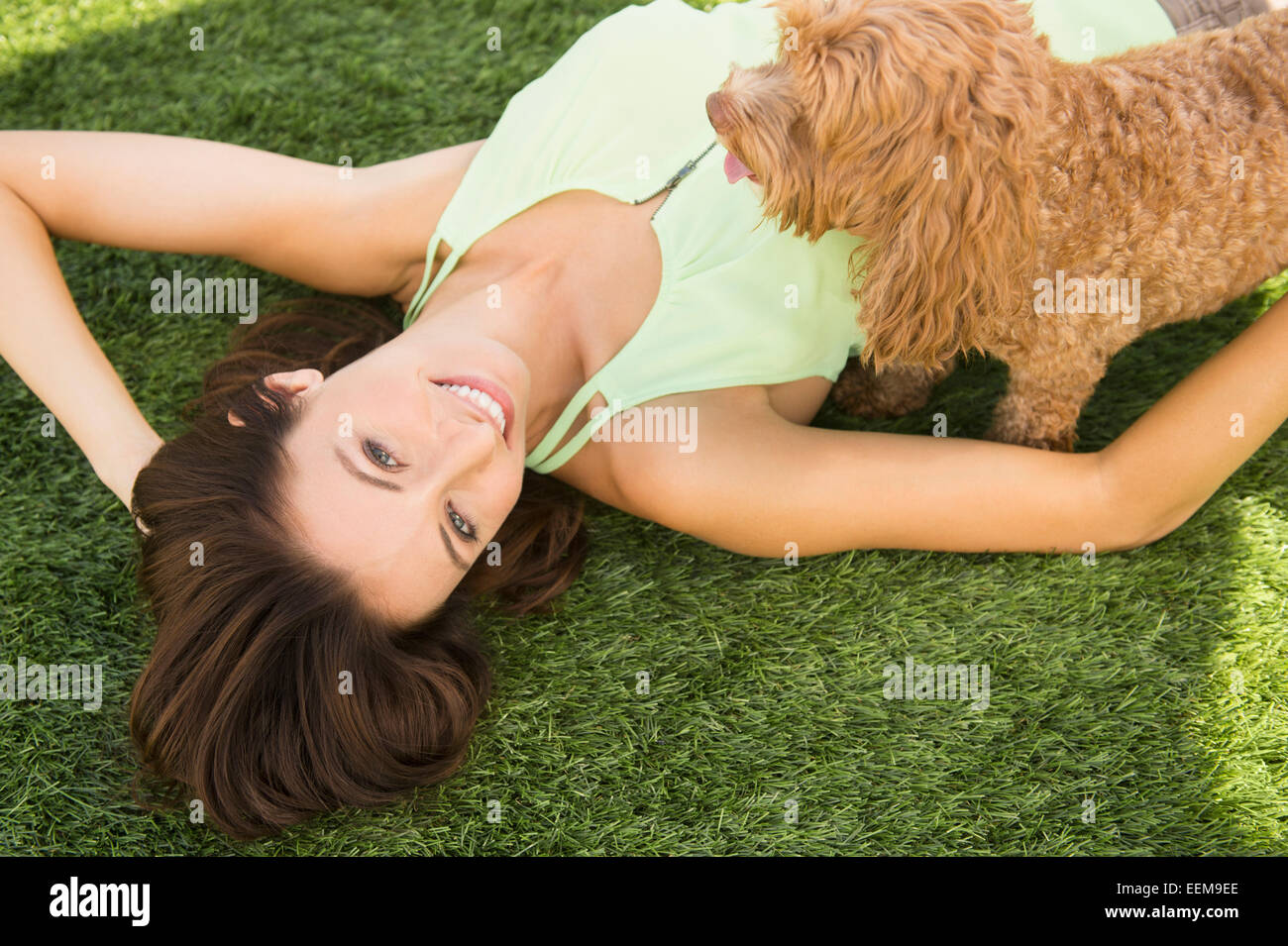 Caucasian woman playing with dog on lawn Stock Photo