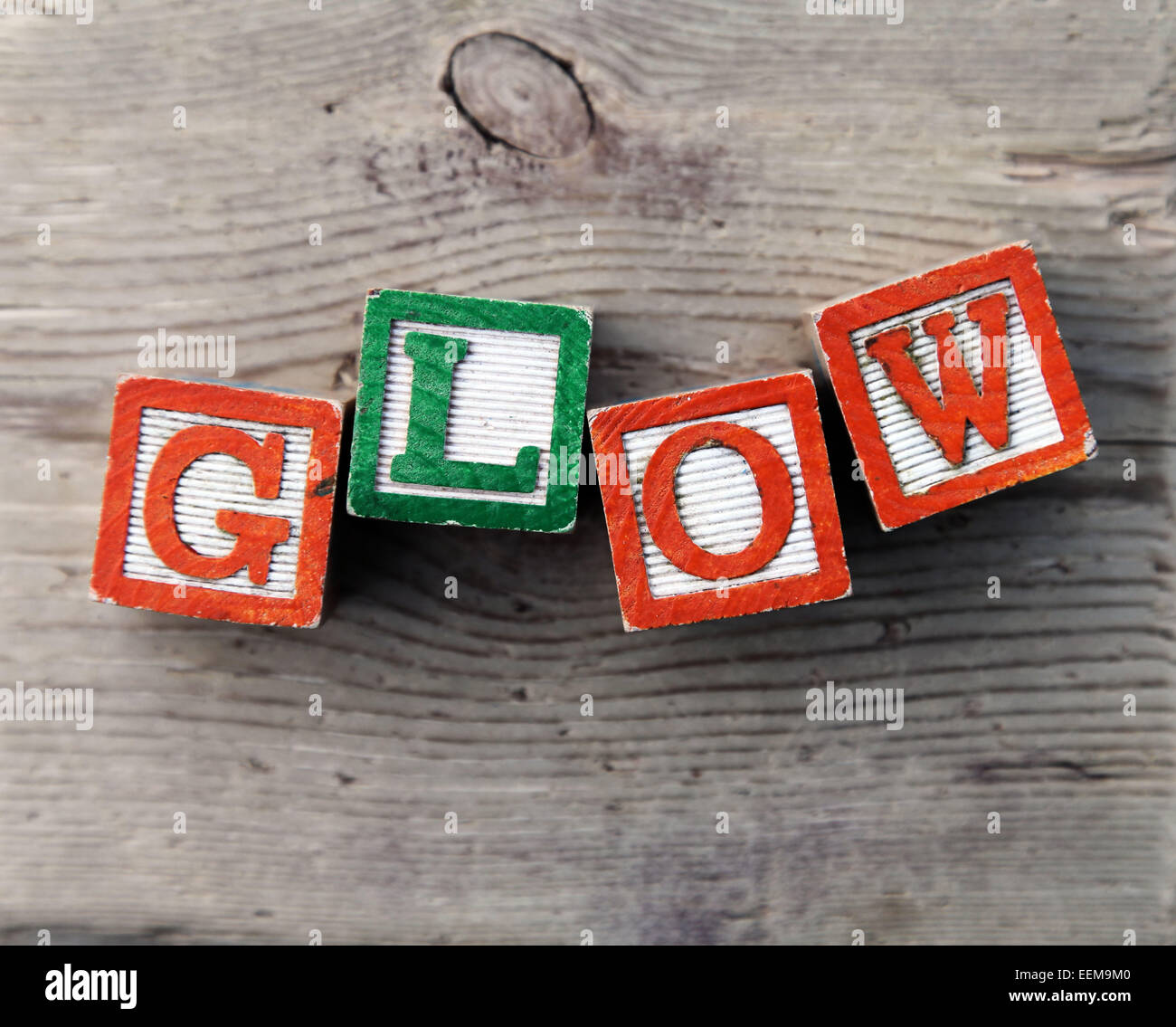 It's a photo top view of wood blocks or wood cubes combined together to create the word GLOW Stock Photo