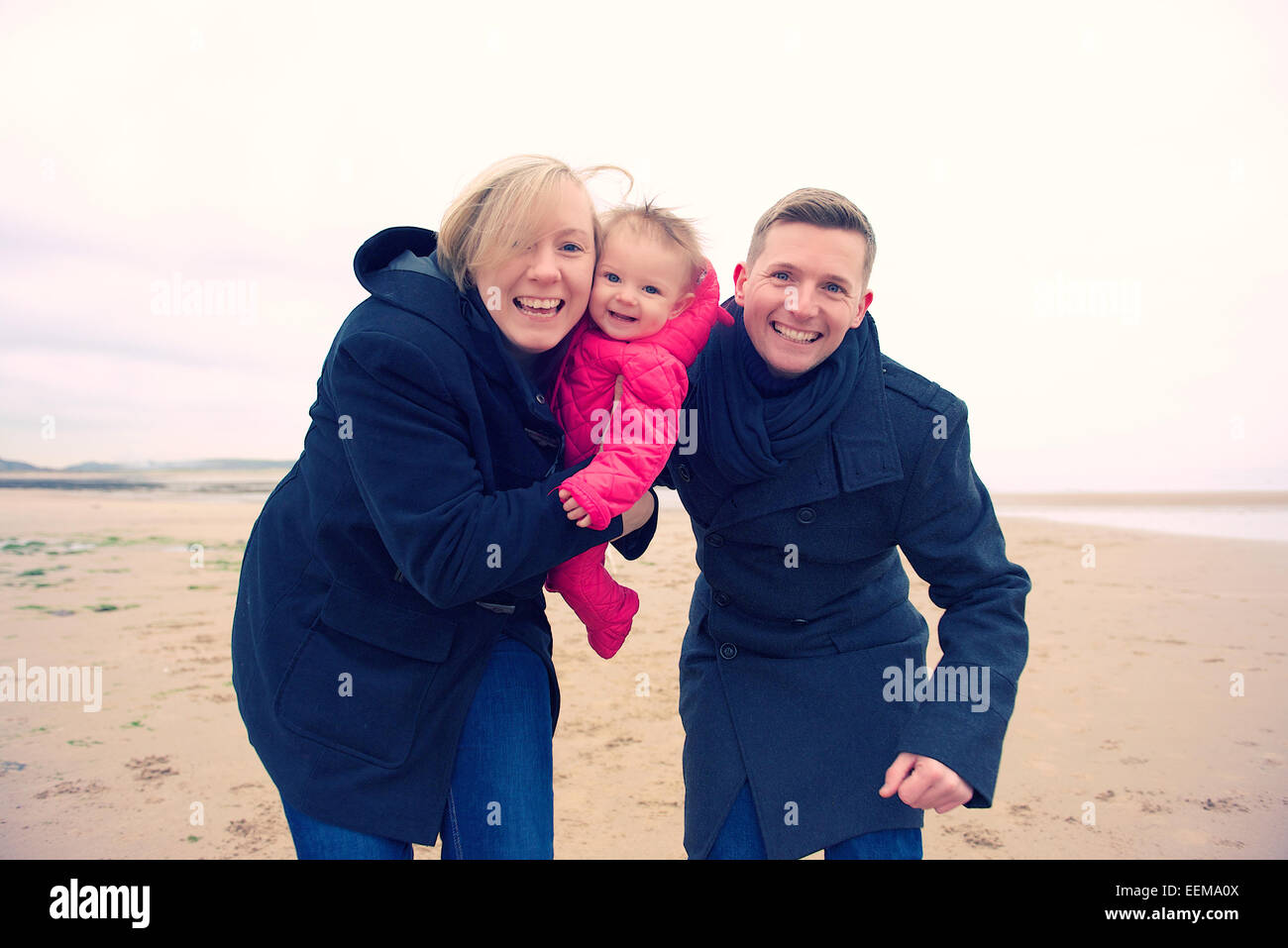 Happy couple with their baby on beach in winher, Porthcawl, Bridgend, Wales, UK Stock Photo