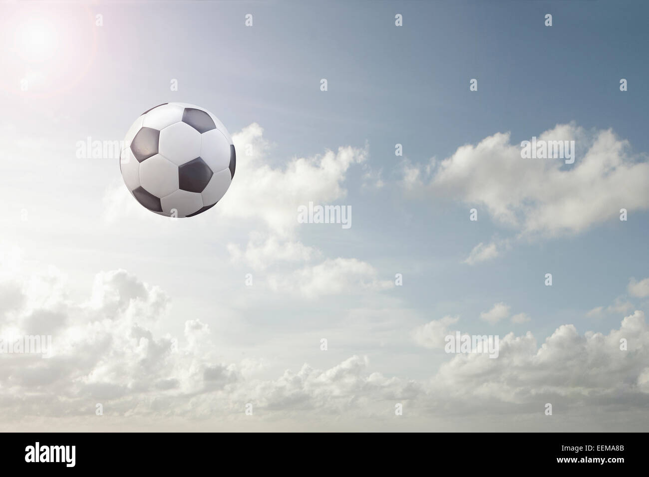 Soccer ball flying in cloudy sky Stock Photo