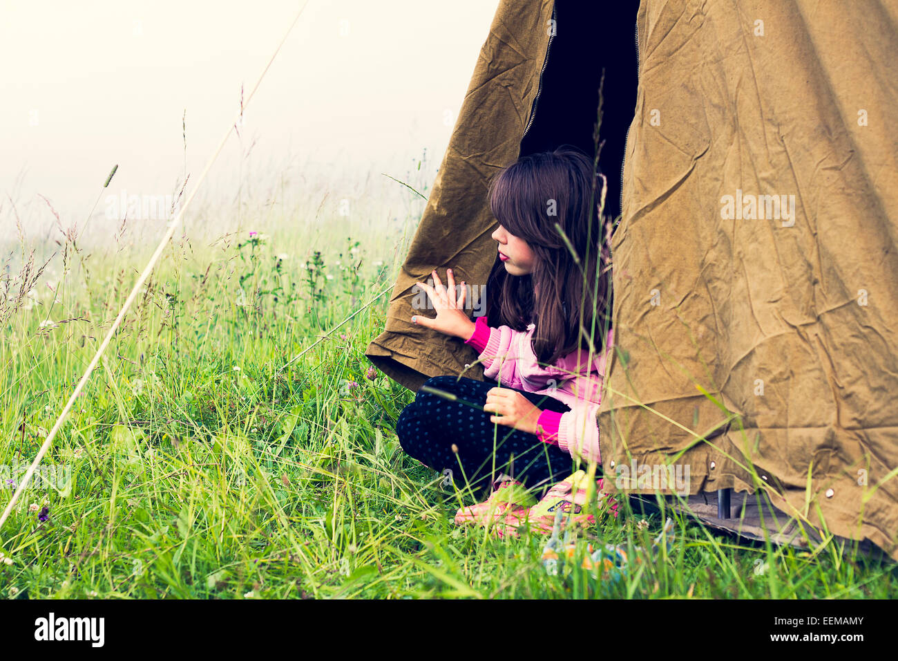 Caucasian girl sitting in camp tent Stock Photo